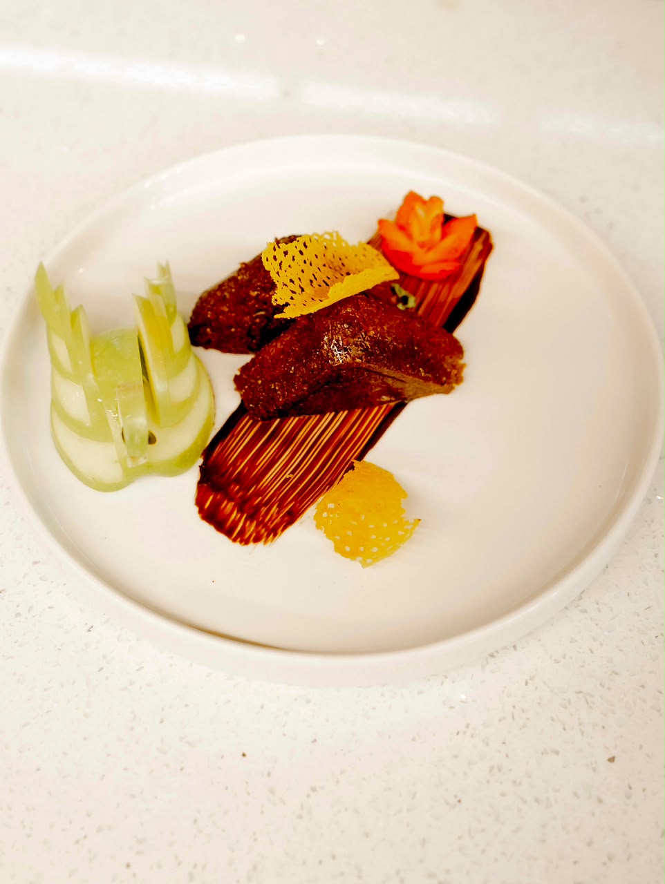 Chef-plated main course with jus brushstroke and tomato rose